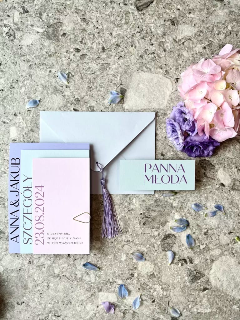 Kompozycja zaproszeń „Liliowa Harmonia” z trzema kartami w pastelowych odcieniach, ozdobiona eleganckimi czcionkami.